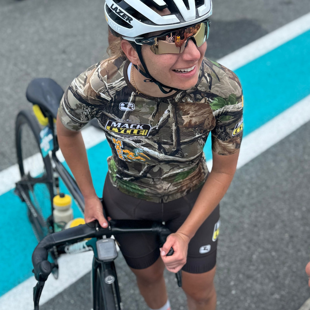 rachel at the finish of DCC 2026 wearing the team hurricanes x mack cycle Giordana "Hunting Season" RealTree Camo Kit Design