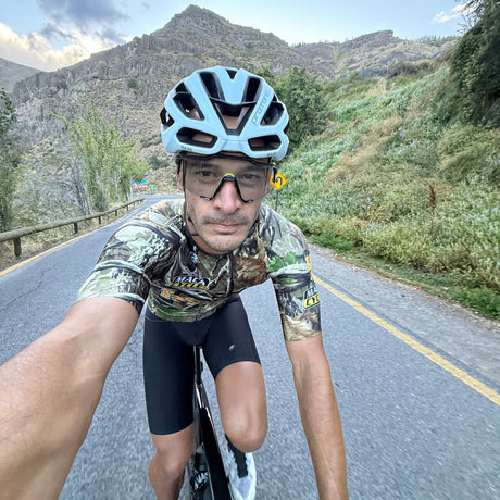 Mario Fava, on a road in Chile wearing his Giordana RealTree Camo jersey with mountains in the background