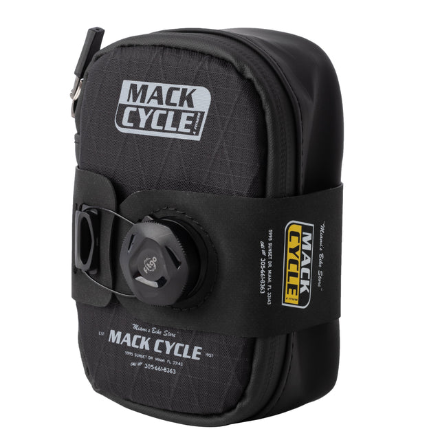 Angled front view showing full mack cycle seat bag profile with branding and dial strap system